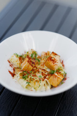 Pasta with red fish in a white plate on the table