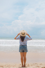 Fototapeta na wymiar Girl in a hat on the beach 
