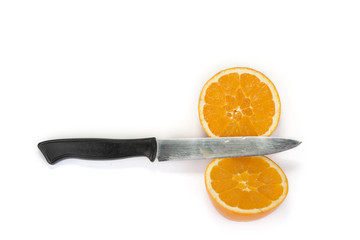 Cut orange on two  halves with kitchen knife on the white