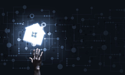 Conceptual image with hand pointing at house or main page icon on dark background