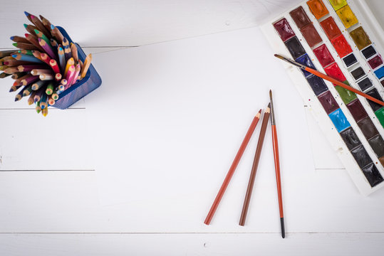 Paints, pencils and brushes on wooden to a floor. Image preprocessing