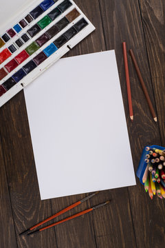 Paints, pencils and brushes on wooden to a floor. Image preprocessing