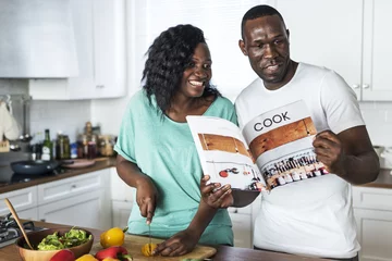 Photo sur Aluminium Cuisinier Couple noir cuisinant ensemble dans la cuisine
