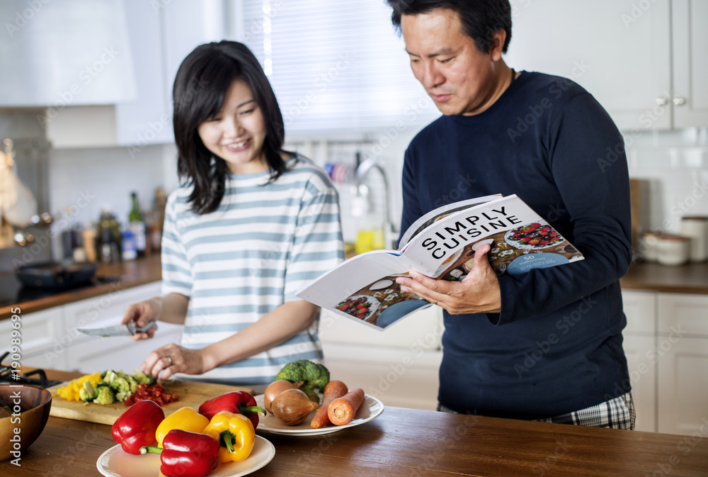 Wall mural asian couple cooking in the kitchen