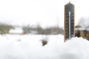 Thermometer on snow shows low temperatures under zero. Cold winter weather under zero.