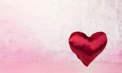 Satin heart on light red background.Valentine's Day concept