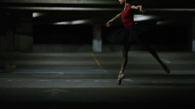 Ballet dancer twirling in urban surroundings, in slow motion