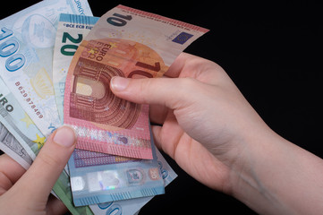 Hand holding American dollar  isolated on black background