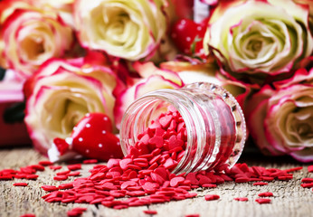 Red sweet heart, Valentines Day card on background of fresh pink and white roses, selective focus