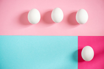 Fresh white eggs over blue and pink background