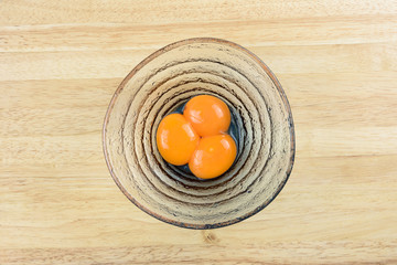 Close up from top view of egg yolks in glasses bowl