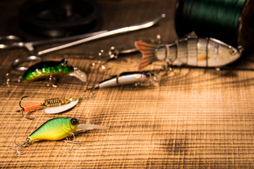 Fishing concept with gear, artificial bait on a predator on a wooden background, top view wobblers...