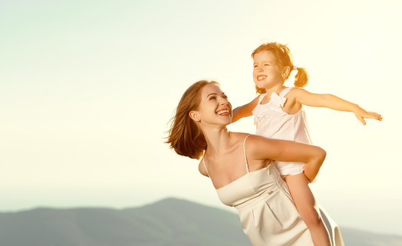 Happy family in summer outdoors.   mother  hug child daughter and laughing