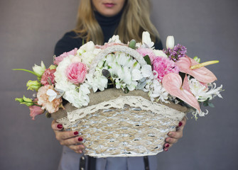The beautiful rustic bouquet of flowers on wicker basket in woman hands