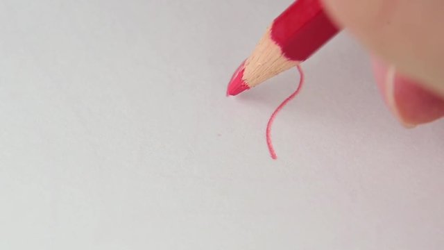 Drawing heart on white drawing paper with red color pencil. artistic concept.