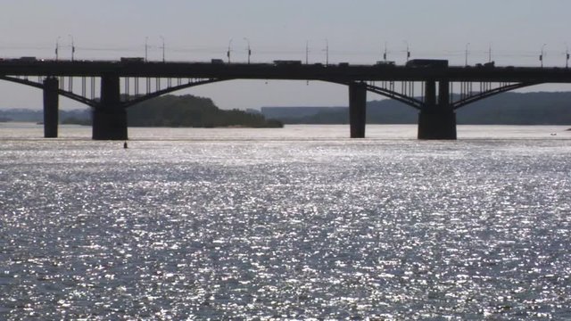 Bridge through river with sun patches of light on water