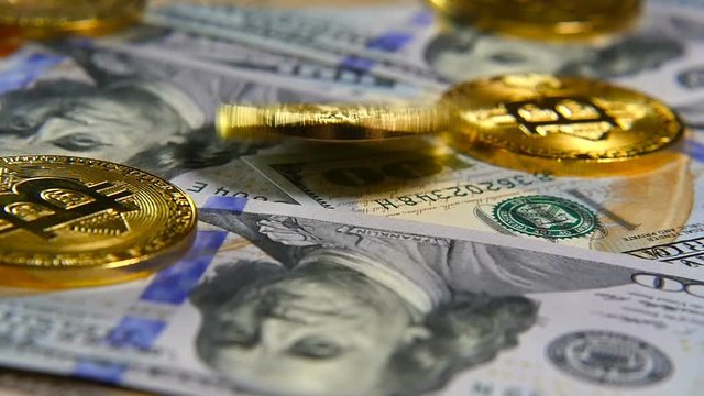 Gold coins of bitcoins and a background of hundred-dollar bills. The concept of financial operations. Economy of the future
