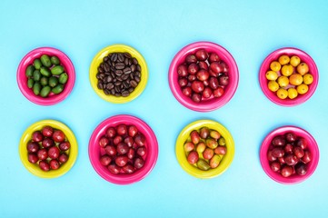 Coffee beans and fresh berries coffee beans on plate on blue background