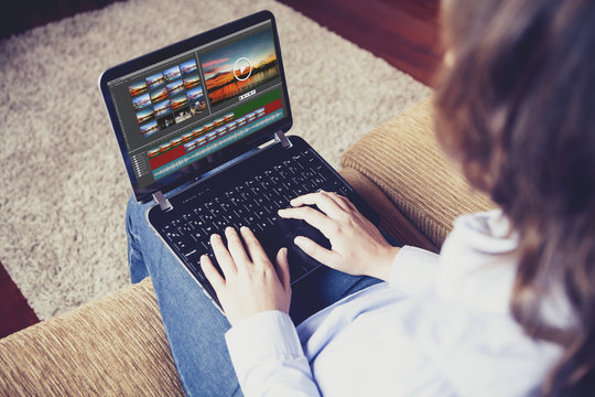 Woman Editing Video With A Laptop While Sitting On The Sofa At Home