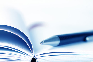 selective focus of ball pen on opened lined diary book