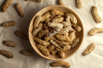 boiled peanuts in wooden cup on crumpled paper