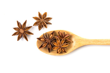 Close up the brown star anise spice in wooden spoon isolated on white background