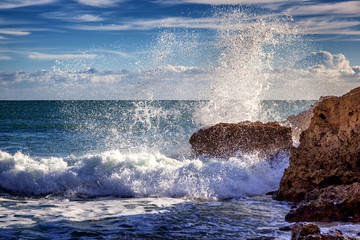Beautiful rocky coast of the ocean, stunning beautiful landscape of the Algarve, Portugal, waves crash against the shore in splashes, travel to Europe