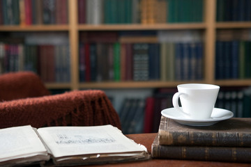 Sweet moments of relaxation with books and a cup of coffee. Vintage books, glasses, chair, library