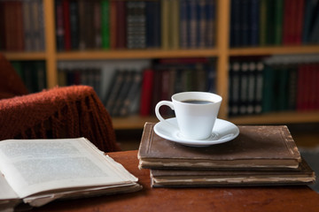 Sweet moments of relaxation with books and a cup of coffee. Vintage books, glasses, chair, library