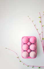 Pink easter eggs in pink box with decoration, on white background with copy space; easter wallpaper