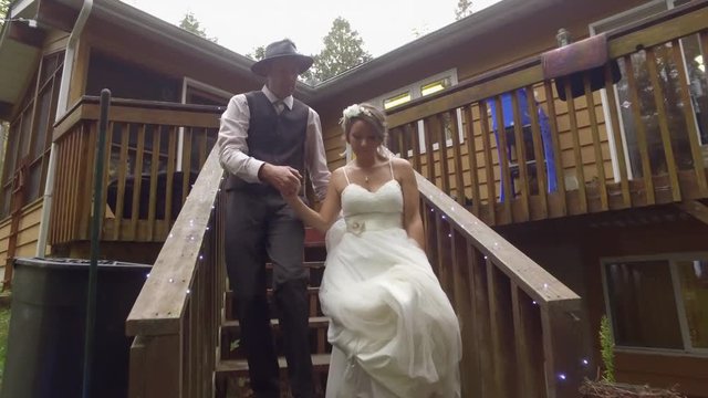 newly weds walk down old stair set at cottage gimbal follow cam 4k