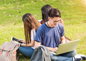 Happy group friends students sitting in park at university