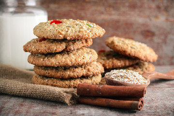 Homemade oatmeal cookies and a cup of milk on a wooden table