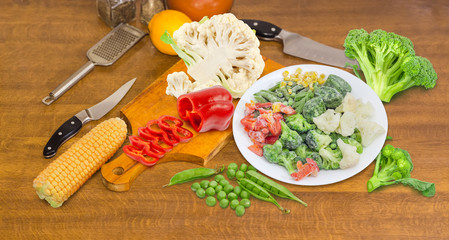 Various frozen and fresh vegetables on a cooking table