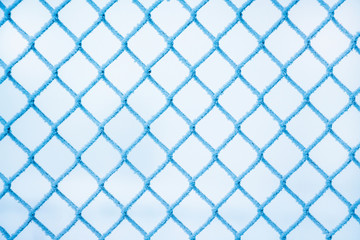 Fototapeta premium winter, a grid of fence, covered with hoarfrost, a frosty winter day_