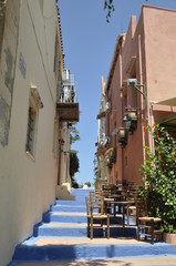 greece island krit Rethymnon street climb up with blue steps on them little brown wooden tables