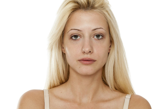 Young blonde woman without makeup on white background