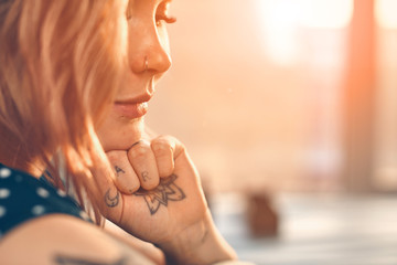 Young beautiful girl looks like the tattoo artist doing her tattoo