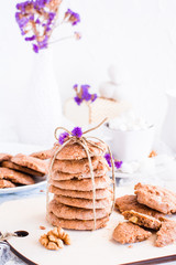 A stack of homemade chocolate cookies tied with a rope. Table setting for breakfast