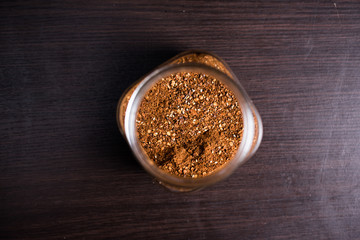 Cayenne pepper in a glass on wood background.