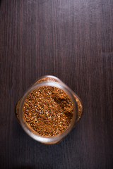 Cayenne pepper in a glass on wood background.