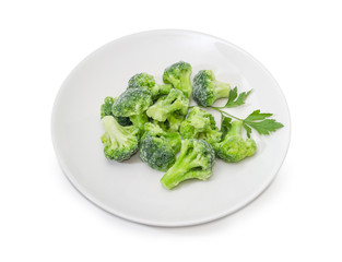 Frozen broccoli with parsley twig on a white dish