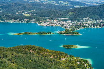 Naklejka premium Wörthersee in Österreich Kärnten mit der Kapuzinerinsel (mittig) und dem Ort Pörtschach im Hintergrund sowie der Schlangeninsel links