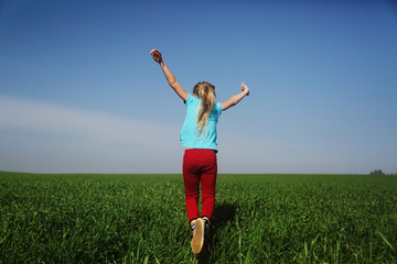 Cute girl jumping in the field