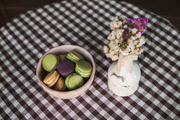 cake lie in a plate on the tablecloth, next to it there is a vase with flowers
