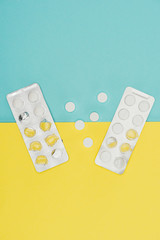 top view of medicines isolated on blue and yellow background