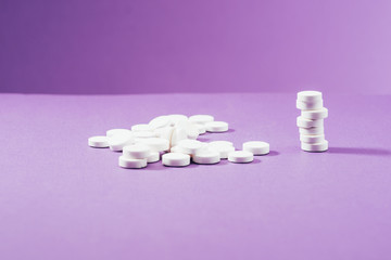 close up view of arranged pills on purple background