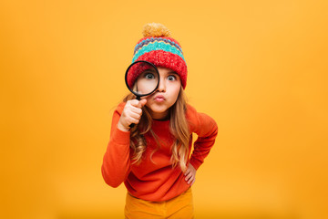 Joyful Young girl in sweater and hat looking at camera
