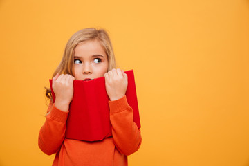 Mystery young girl in sweater hiding behind the book