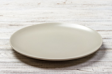 Perspective view. Empty white plate on wooden background